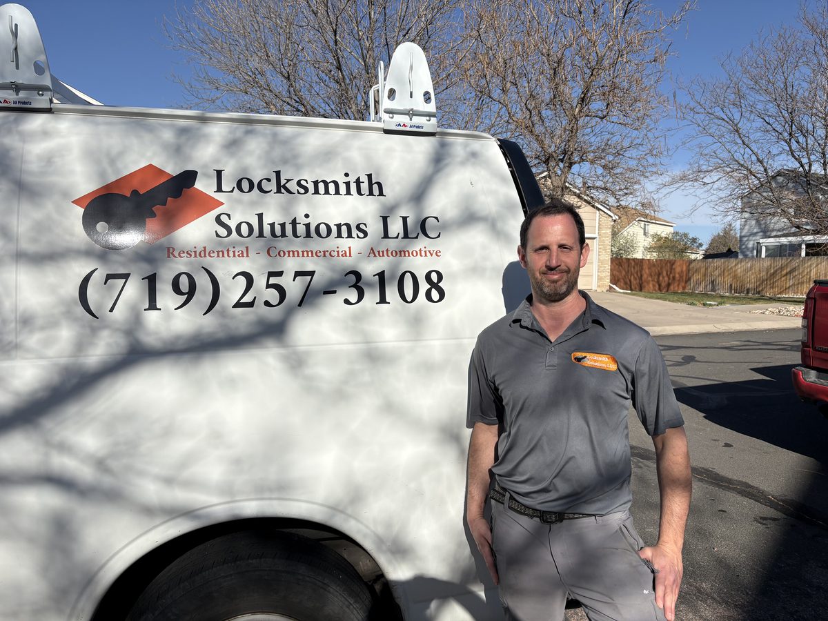 Eyal, owner of Locksmith Solutions LLC, standing beside the mobile locksmith van in Colorado Springs