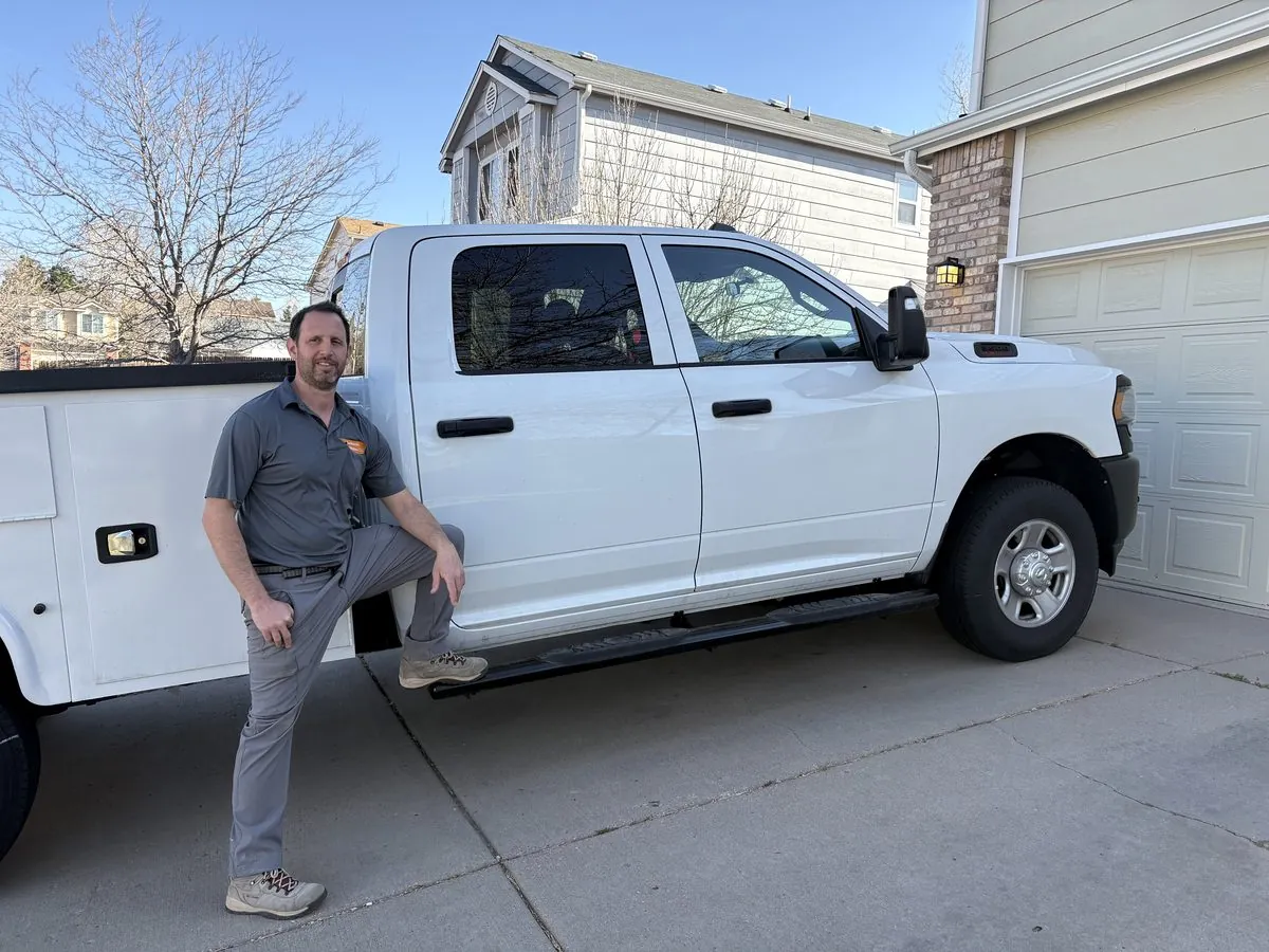 Locksmith Solutions LLC owner standing beside the branded mobile locksmith work truck in a Colorado Springs driveway