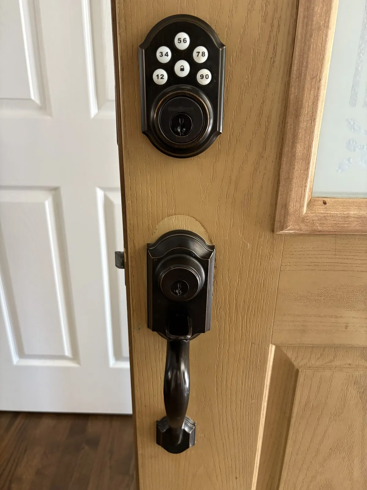 Residential keypad deadbolt and traditional handleset on a Colorado Springs front door, illustrating the choice between rekey and replacement